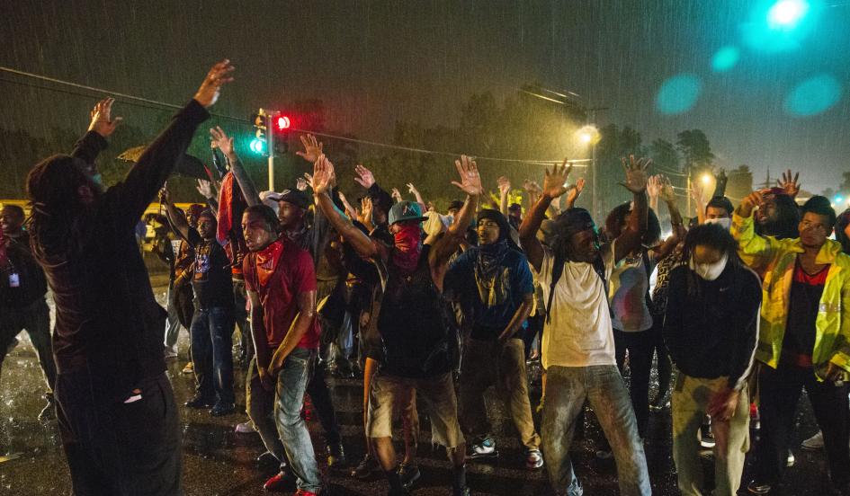 Protesters stand in a street in defiance of a midnight curfew meant to stem ongoing demonstrations in reaction to the shooting of Michael Brown in Ferguson, Missouri August 17, 2014. REUTERS/LUCAS JACKSON