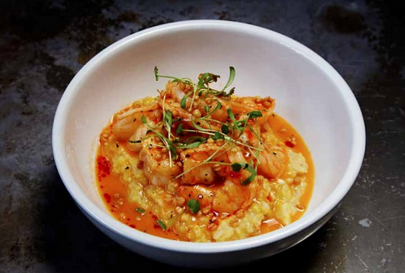 Shrimp and grits with cilantro, chili oil, shrimp butter, over puffed wheat berries ($16)